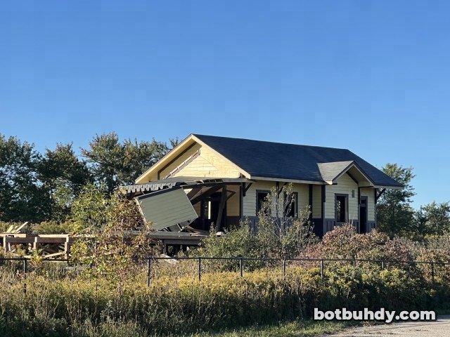The station with its porch roof crumpled down over the front deck.